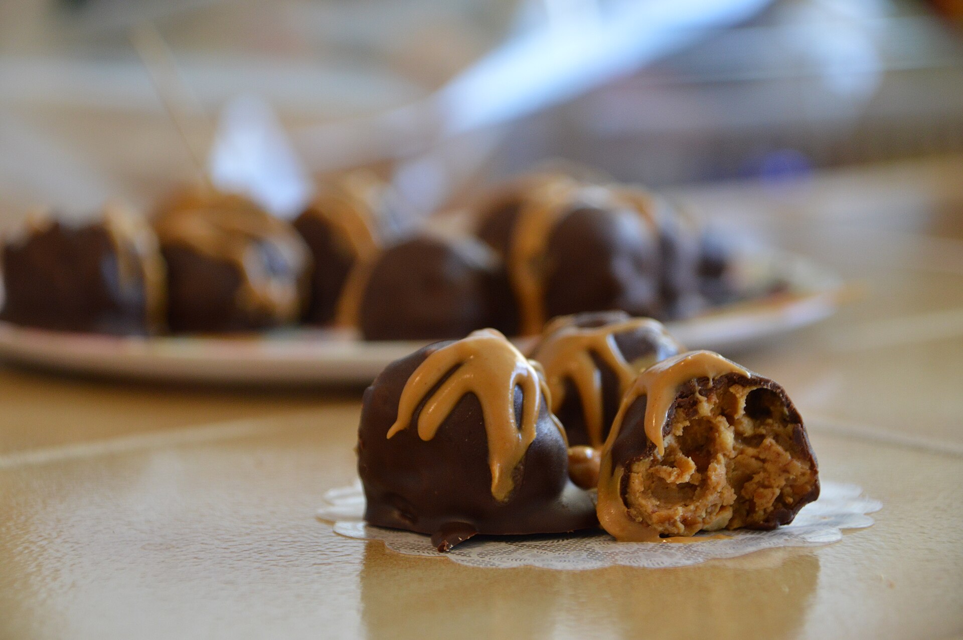 Trufas de chocolate com cobertura de amendoim sobre a bancada.